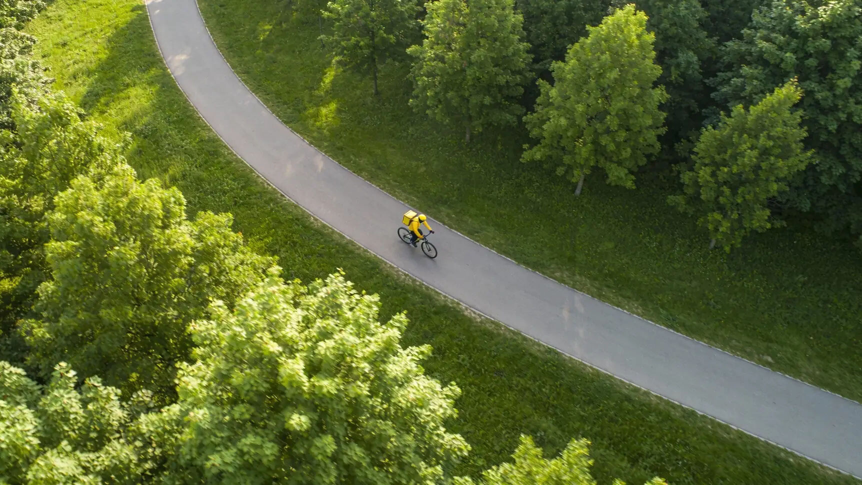 Курьер надежно пристегивает свой электробайк стальной цепью к велопарковке